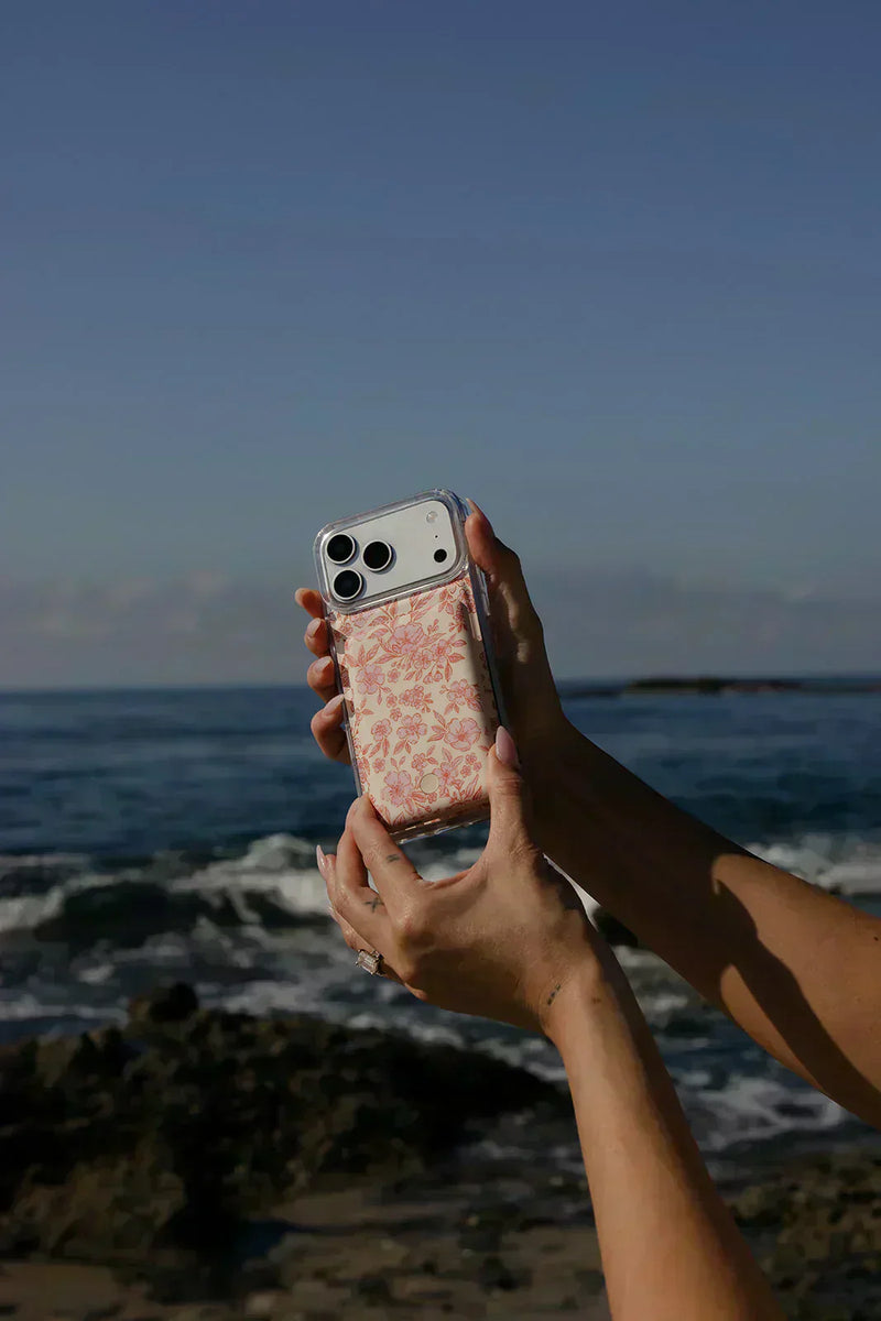 Woman holding an iPhone with a Walli magnetic power bank.